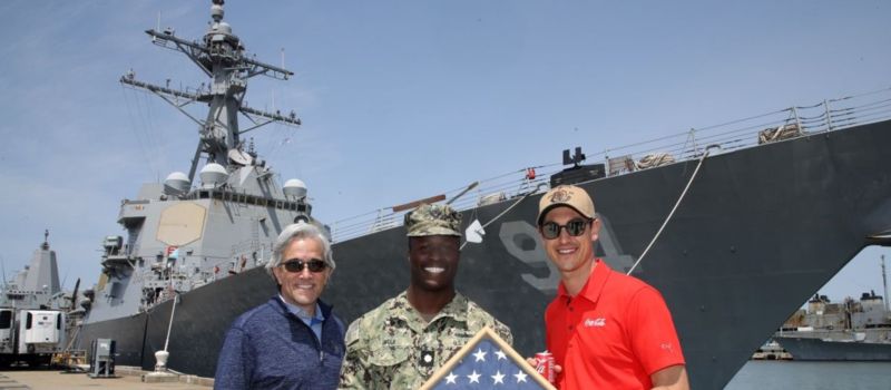 Coca-Cola Racing Family driver Joey Logano (right), Charlotte Motor Speedway Executive Vice President and General Manager Greg Walter (left) and NASCAR Salutes ambassador Jesse Iwuji pose for the photo in front of the USS Nitze during a Mission 600 visit to Naval Station Norfolk on Wednesday, May 10.